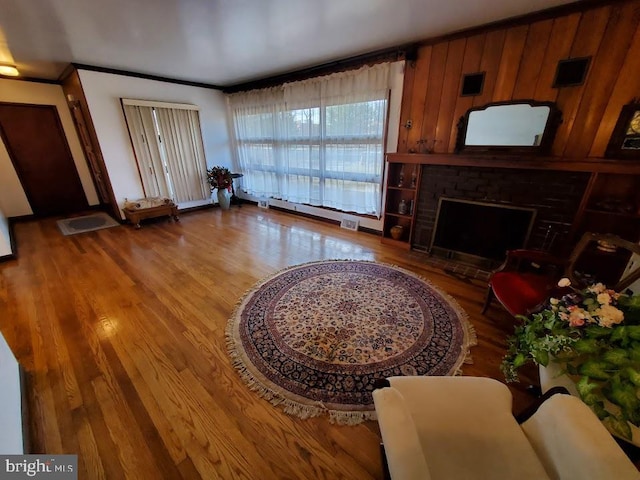 living room featuring wooden walls, wood-type flooring, and a fireplace