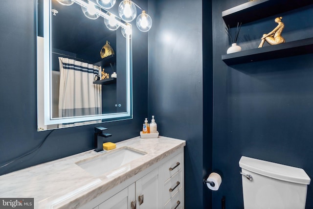 bathroom with vanity, a shower with shower curtain, and toilet