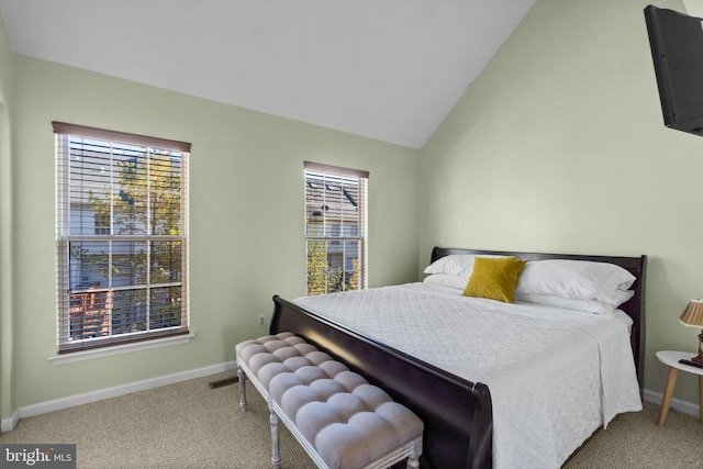 bedroom featuring multiple windows, light colored carpet, and lofted ceiling