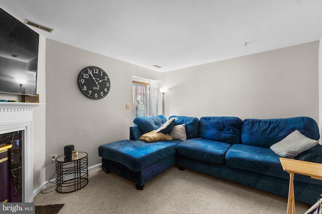 living room with carpet and a fireplace