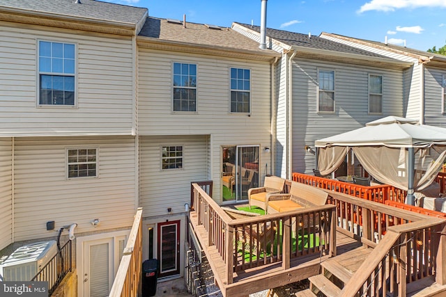 rear view of house featuring a wooden deck