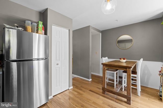 kitchen with light hardwood / wood-style flooring and stainless steel fridge