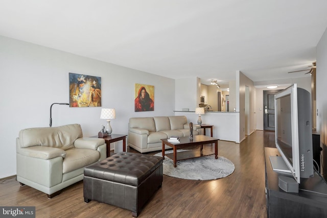 living room featuring ceiling fan and dark hardwood / wood-style floors