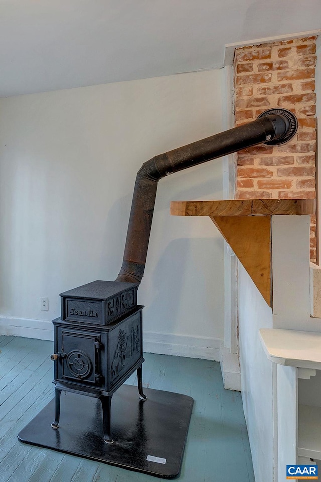 interior details with hardwood / wood-style floors and a wood stove