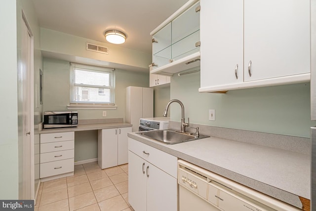 kitchen featuring dishwasher, white cabinets, sink, and light tile patterned floors