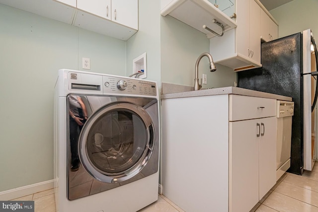 laundry area with light tile patterned flooring, sink, cabinets, and washer / dryer