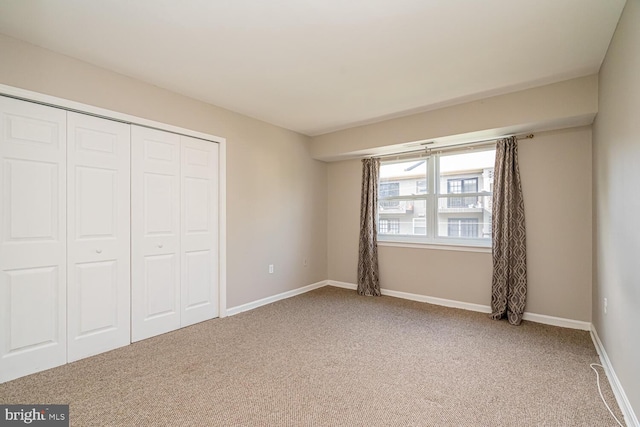 unfurnished bedroom with a closet and carpet flooring