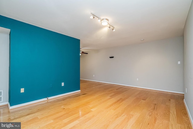 unfurnished room featuring ceiling fan, light wood-type flooring, and rail lighting