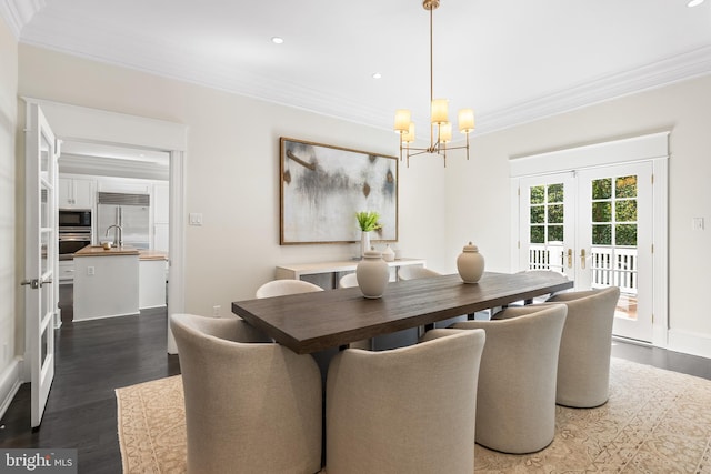 dining room featuring a chandelier, french doors, crown molding, and dark wood-type flooring