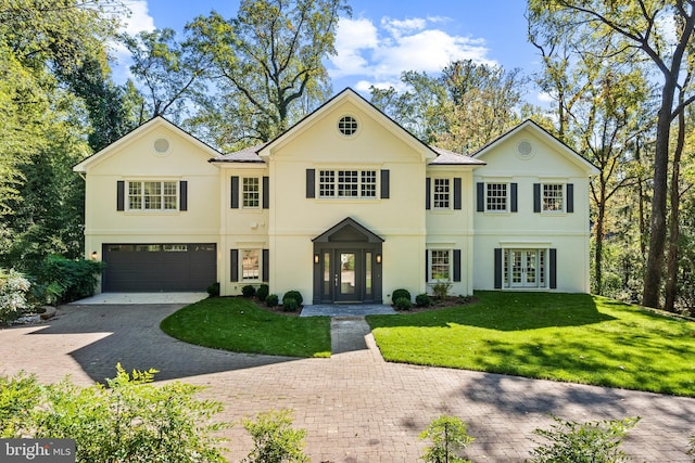 view of front of house with a front lawn, a garage, and french doors