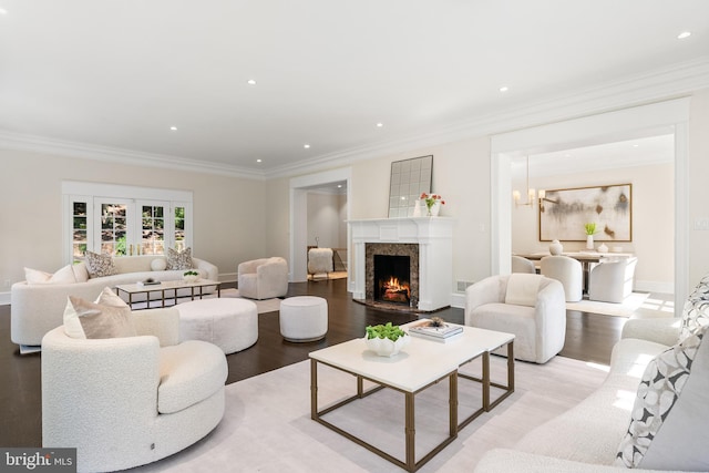 living room featuring light hardwood / wood-style floors, ornamental molding, and a premium fireplace