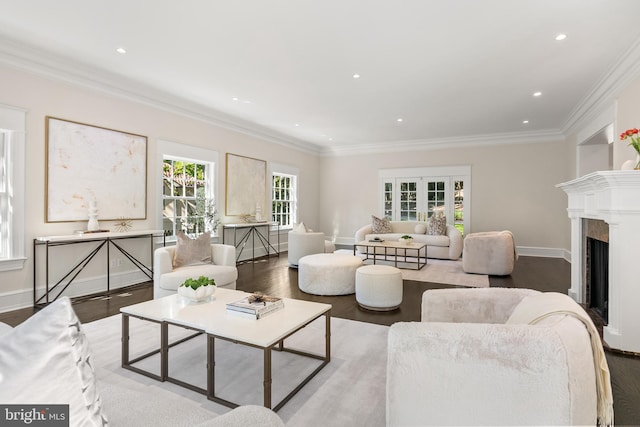 living room featuring crown molding, light hardwood / wood-style flooring, a high end fireplace, and a healthy amount of sunlight