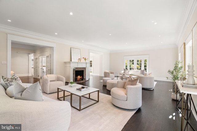 living room featuring french doors, a high end fireplace, wood-type flooring, and ornamental molding