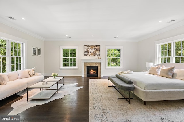 bedroom with dark hardwood / wood-style floors, crown molding, a fireplace, and multiple windows