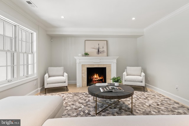 sitting room featuring a tile fireplace and crown molding