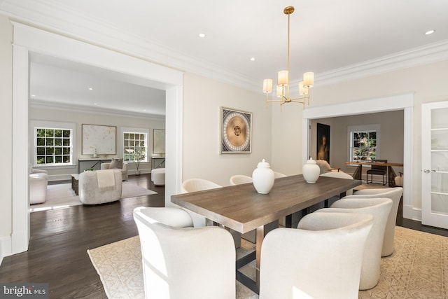 dining space featuring a notable chandelier, ornamental molding, and dark wood-type flooring