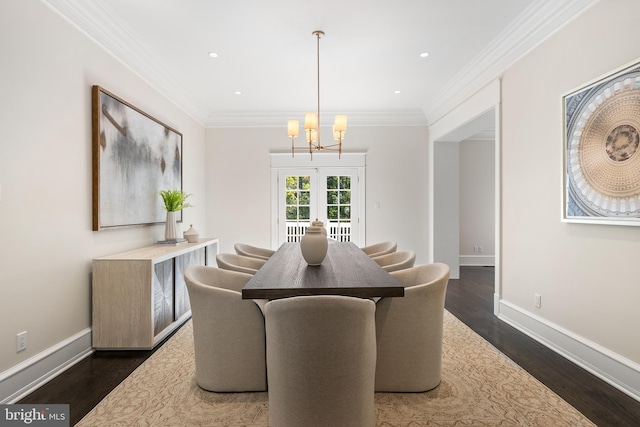 dining room with french doors, dark hardwood / wood-style flooring, ornamental molding, and a notable chandelier