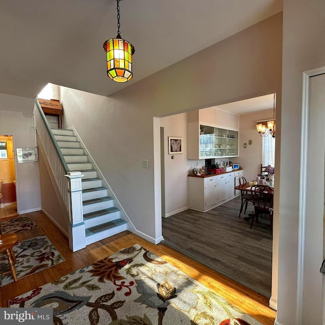 interior space with lofted ceiling, wood-type flooring, and an inviting chandelier