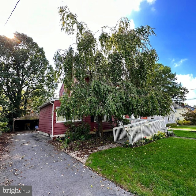 view of side of property with a carport and a yard