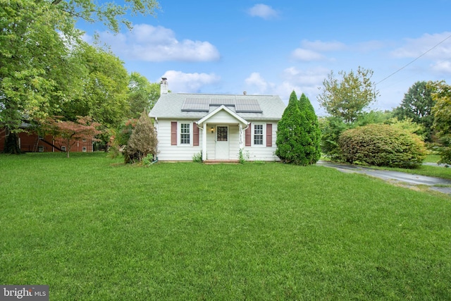 view of front of property with solar panels and a front lawn