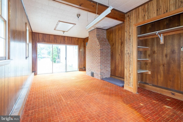 unfurnished living room featuring wooden walls