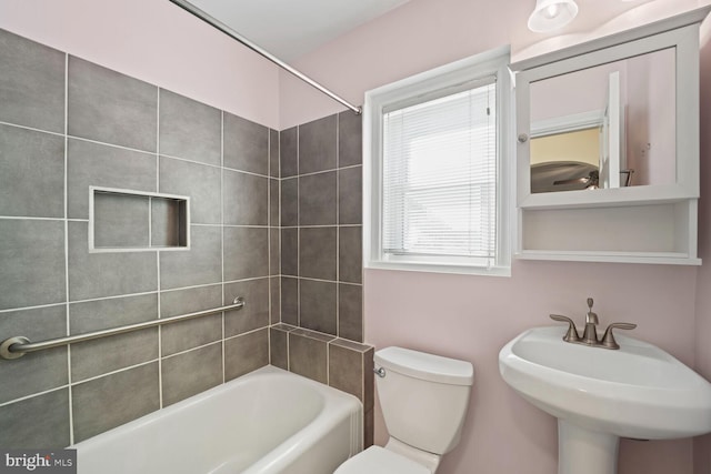 full bathroom with sink, toilet, and tiled shower / bath combo