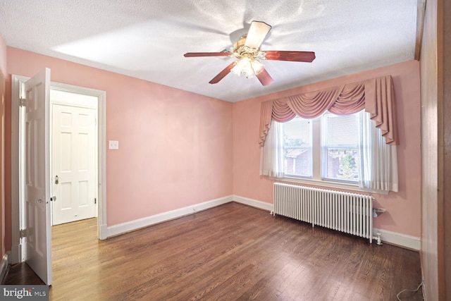 spare room with ceiling fan, a textured ceiling, hardwood / wood-style floors, and radiator heating unit