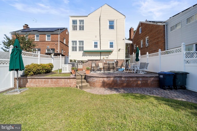 rear view of house featuring a yard and a patio