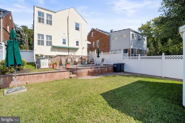 rear view of house with a fire pit, a lawn, and a patio area