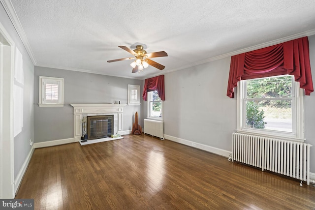 unfurnished living room featuring plenty of natural light, dark hardwood / wood-style flooring, and radiator