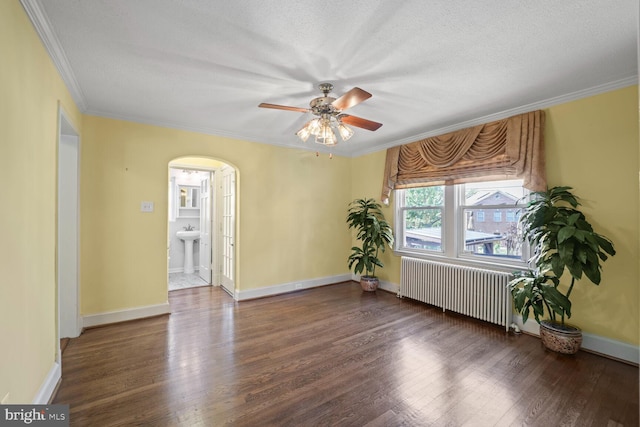 empty room featuring ceiling fan, radiator heating unit, crown molding, dark hardwood / wood-style flooring, and a textured ceiling