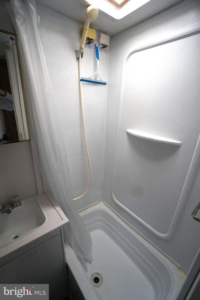 bathroom with shower / bathtub combination with curtain and sink