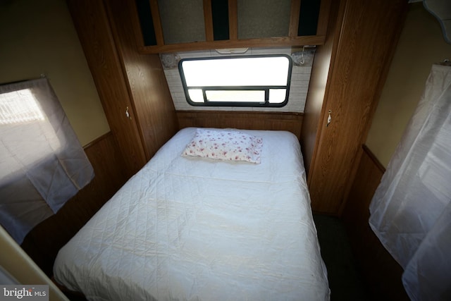 bedroom featuring wood walls