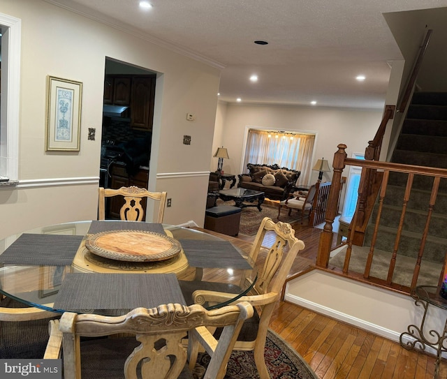 dining room featuring hardwood / wood-style flooring, a textured ceiling, and crown molding