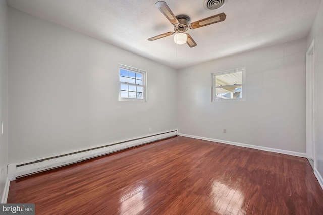 unfurnished room featuring dark hardwood / wood-style flooring, ceiling fan, and a baseboard heating unit