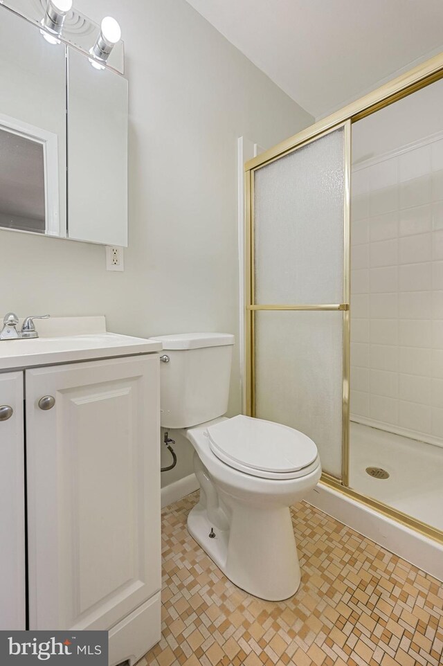 bathroom with vanity, toilet, and a shower with shower door