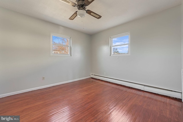 unfurnished room featuring baseboard heating, ceiling fan, and dark wood-type flooring