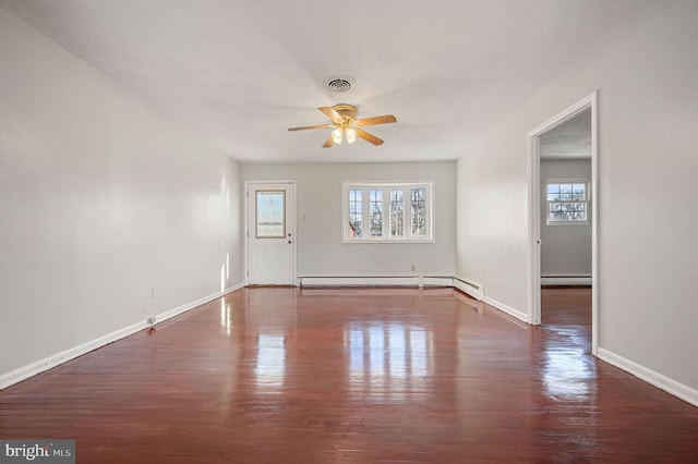 unfurnished room featuring baseboard heating, ceiling fan, and dark wood-type flooring