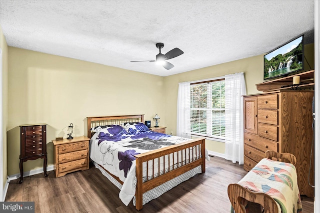 bedroom with ceiling fan, wood-type flooring, and a textured ceiling