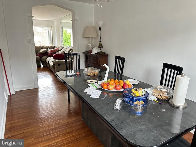 dining area with a notable chandelier and dark wood-type flooring