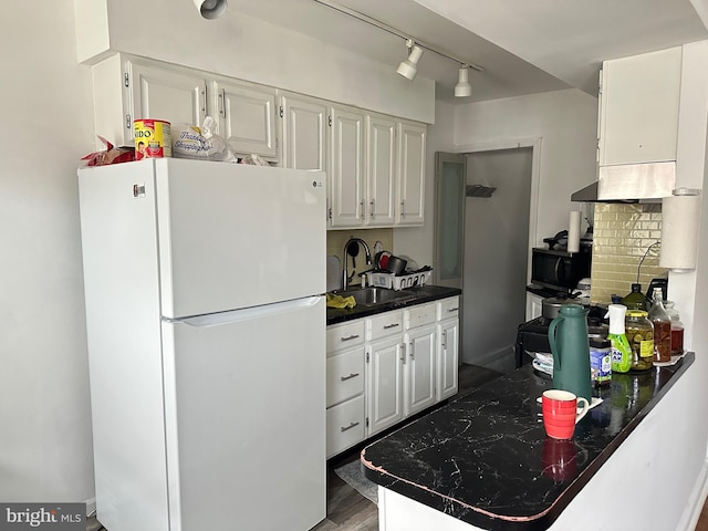 kitchen featuring white cabinets, tasteful backsplash, white refrigerator, hardwood / wood-style flooring, and sink