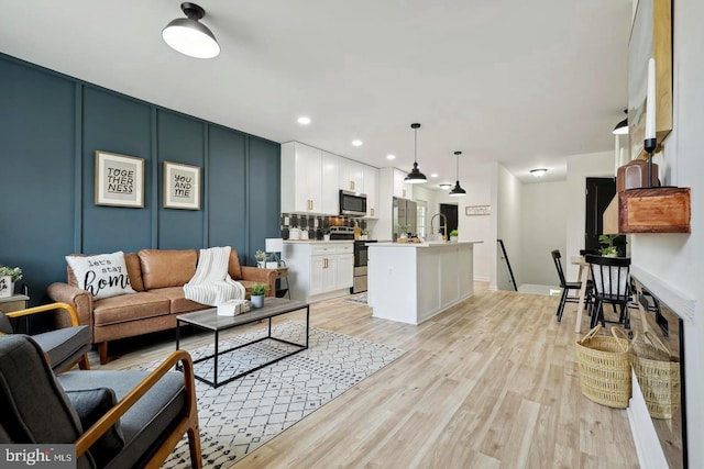 living room with sink and light wood-type flooring