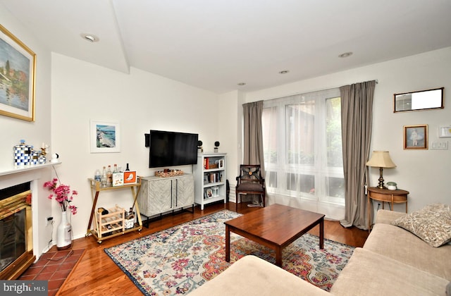 living room with dark hardwood / wood-style flooring and a tile fireplace