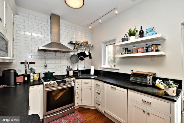 kitchen with decorative backsplash, dark hardwood / wood-style flooring, wall chimney range hood, and stainless steel range oven