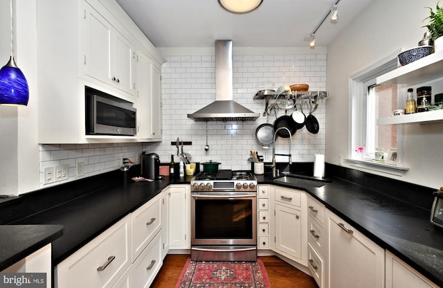 kitchen featuring wall chimney exhaust hood, dark hardwood / wood-style floors, stainless steel appliances, backsplash, and white cabinets