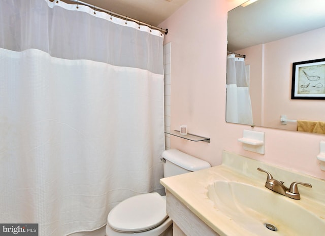 bathroom featuring curtained shower, vanity, and toilet