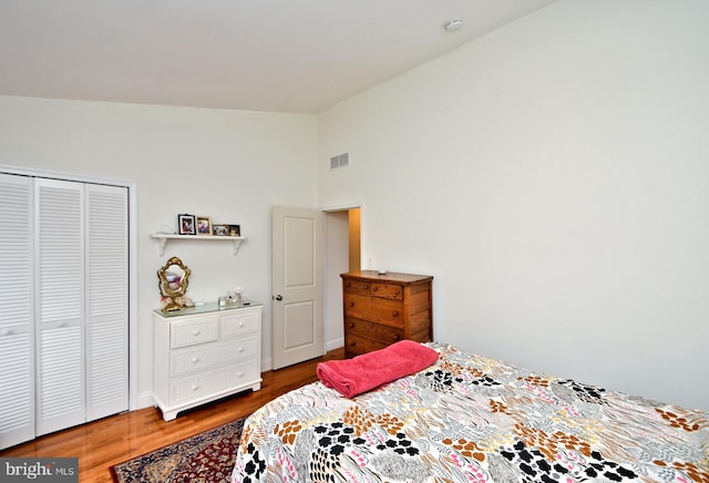 bedroom featuring hardwood / wood-style flooring, a closet, and lofted ceiling