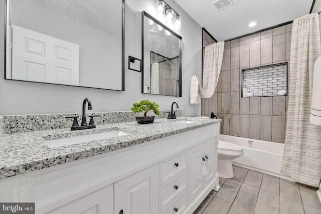 full bathroom featuring shower / bath combo with shower curtain, vanity, and toilet