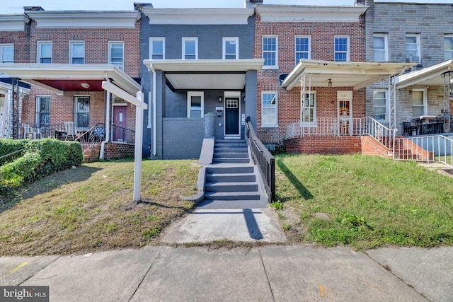 townhome / multi-family property with a front lawn and covered porch