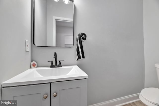 bathroom with vanity, toilet, and wood-type flooring